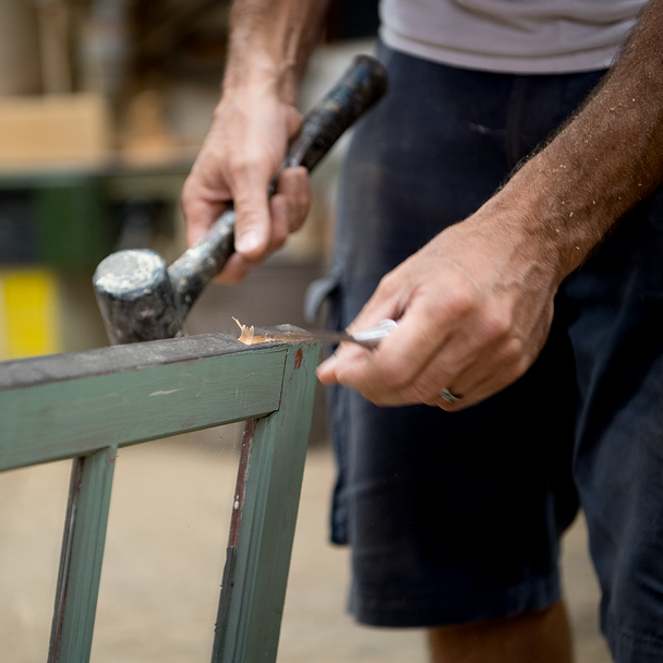 Person with handheld tools, repairing a window pane